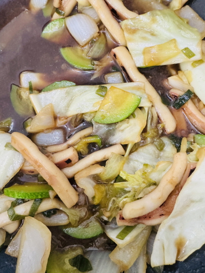 금음체질을 위한 담백한 간장 오징어볶음 이미지: 탱글한 오징어와 부드러운 애호박, 아삭한 양배추·양파를 최소한의 들기름과 진간장 소스로 볶아내어 체내 열을 낮추고 소화를 돕는 건강 반찬 모습