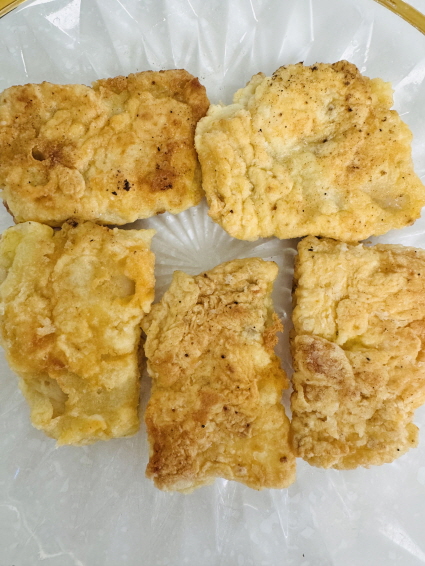 쌀가루 반죽으로 만든 바삭하고 노릇노릇한 올리브 오일 대구전 5개가 접시에 가지런히 놓인 모습